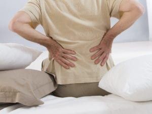 Elderly woman holding back in pain