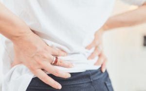 Woman holding hips in pain